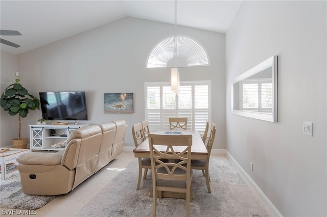 dining area featuring light tile patterned flooring and high vaulted ceiling