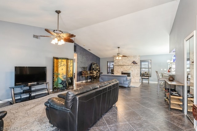 living room featuring a fireplace, vaulted ceiling, and ceiling fan