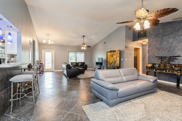 living room with ceiling fan with notable chandelier and high vaulted ceiling