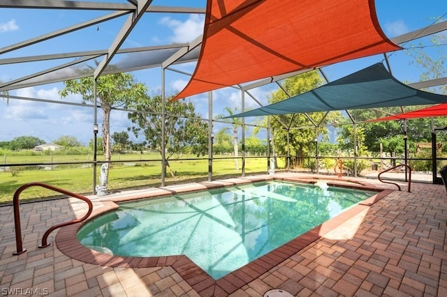 view of swimming pool featuring a patio, a lanai, and a lawn