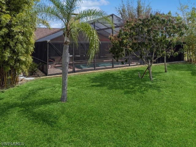 view of yard featuring glass enclosure and a patio