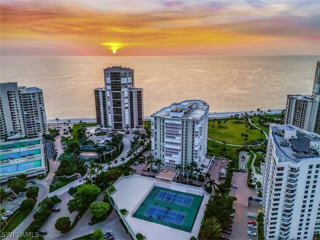 aerial view at dusk featuring a water view