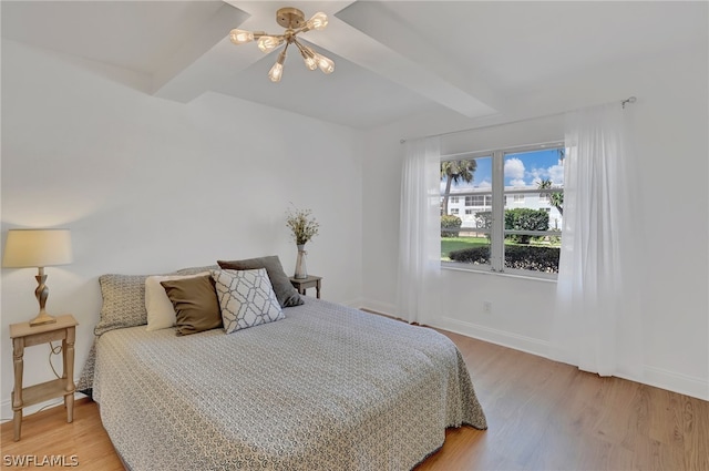 bedroom with an inviting chandelier and light hardwood / wood-style flooring