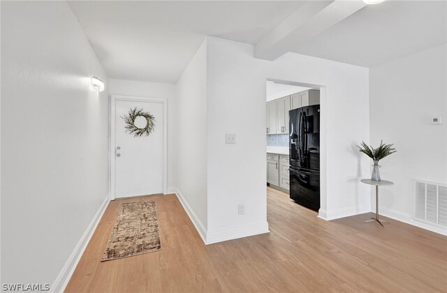 interior space featuring beam ceiling and light hardwood / wood-style floors