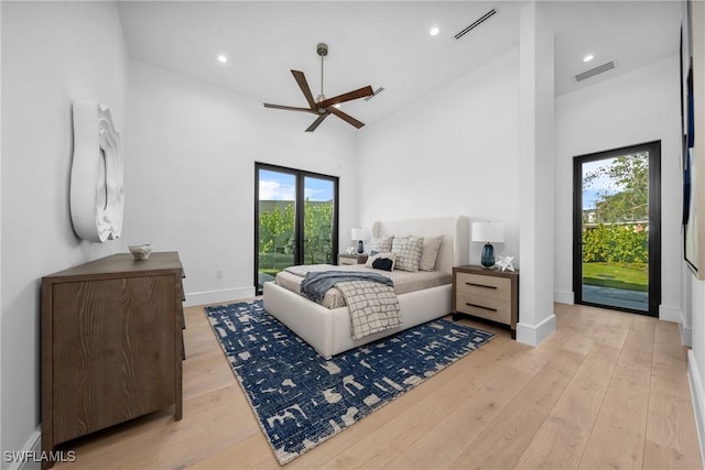 bedroom featuring access to outside, light wood finished floors, high vaulted ceiling, and visible vents