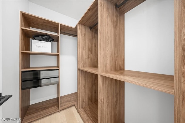 walk in closet with light wood-type flooring