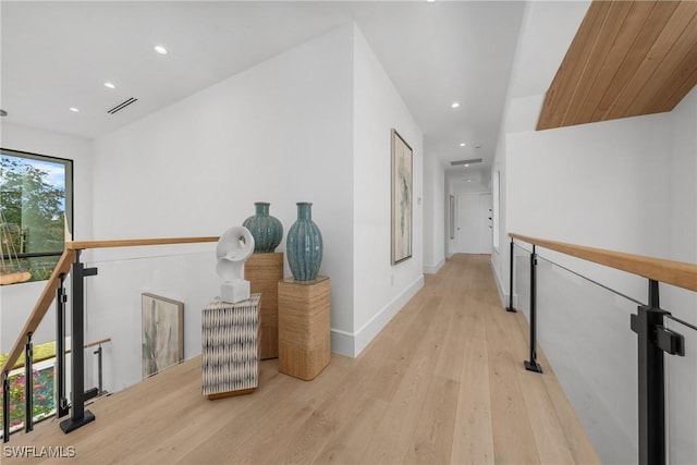 corridor with light wood finished floors, recessed lighting, visible vents, an upstairs landing, and baseboards