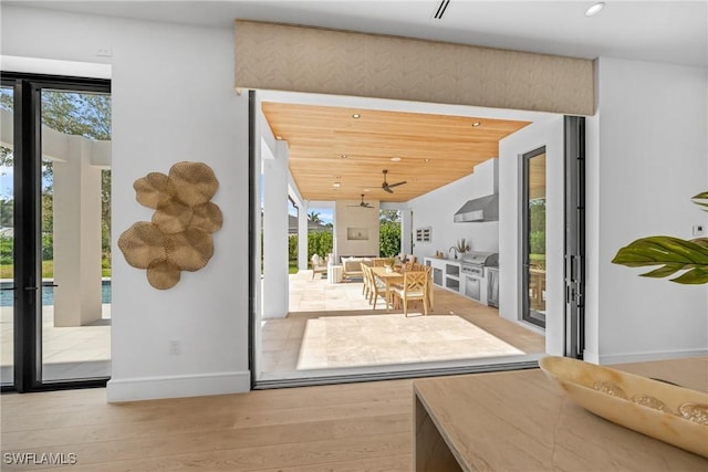 doorway with light wood finished floors, recessed lighting, and baseboards