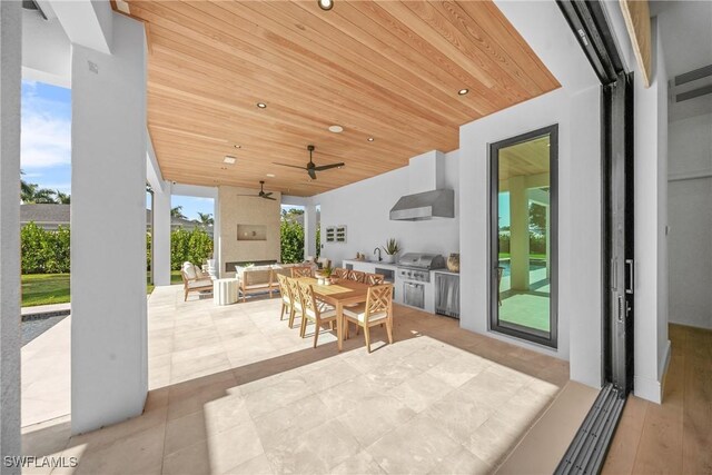 view of patio / terrace with outdoor dining area, an outdoor kitchen, a ceiling fan, a grill, and an outdoor living space