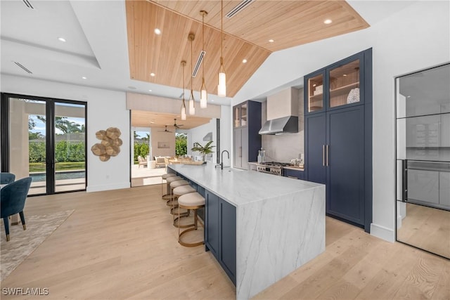 kitchen featuring wooden ceiling, a large island, glass insert cabinets, decorative light fixtures, and blue cabinets