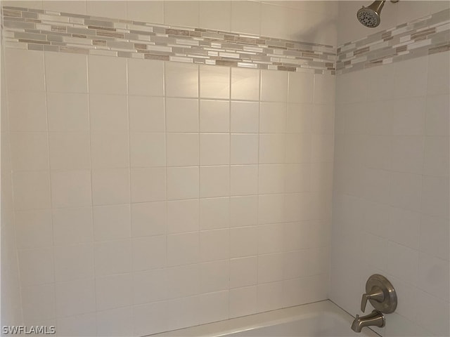 interior details featuring tiled shower / bath combo