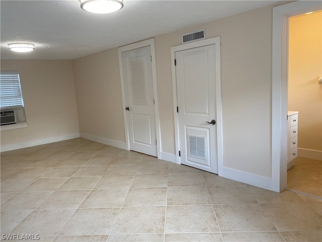 unfurnished bedroom with light tile flooring and a textured ceiling