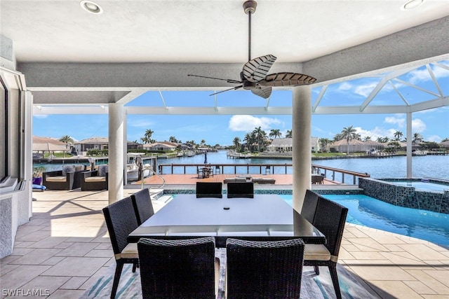 view of patio / terrace featuring a pool with hot tub, a water view, a lanai, and ceiling fan