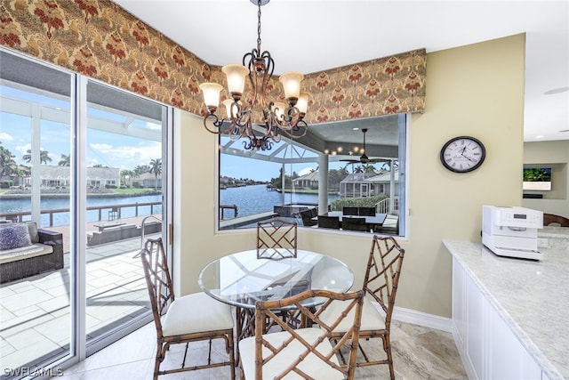 tiled dining area featuring a notable chandelier and a water view