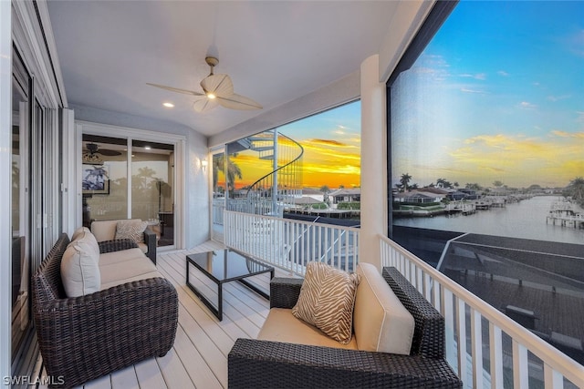 sunroom / solarium featuring a water view and ceiling fan