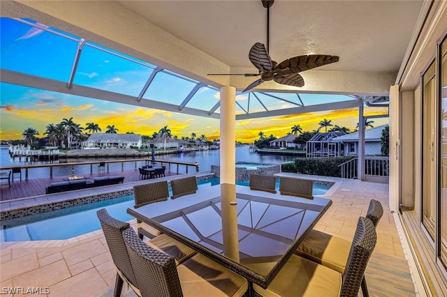 patio terrace at dusk with ceiling fan and a water view