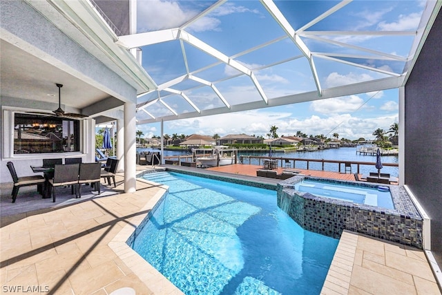 view of swimming pool featuring ceiling fan, an in ground hot tub, glass enclosure, a water view, and a patio area