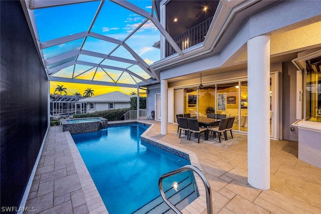 view of swimming pool featuring a patio area, an in ground hot tub, and glass enclosure