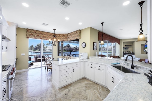 kitchen with stainless steel stove, light tile floors, decorative light fixtures, and sink