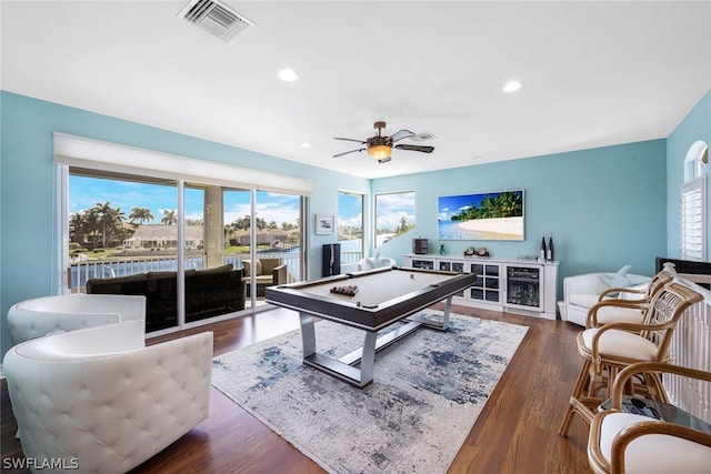 living room featuring dark hardwood / wood-style floors, ceiling fan, and a healthy amount of sunlight