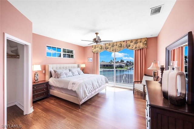 bedroom featuring dark hardwood / wood-style floors, access to exterior, and ceiling fan