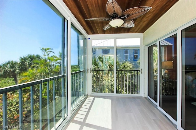 unfurnished sunroom with ceiling fan and wooden ceiling