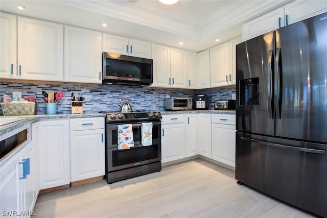 kitchen with white cabinets, backsplash, range with two ovens, and black refrigerator with ice dispenser