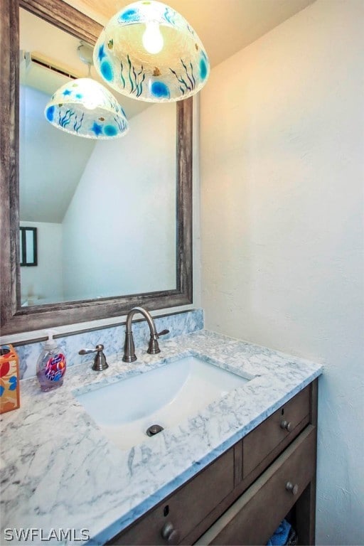 bathroom featuring vaulted ceiling and vanity