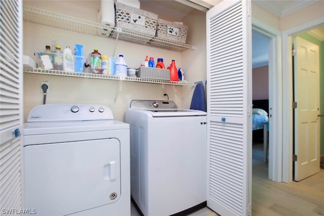 laundry area featuring electric dryer hookup, light hardwood / wood-style flooring, and washing machine and clothes dryer