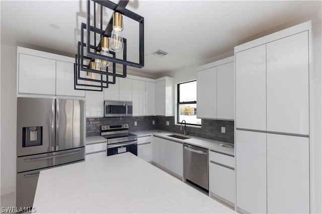 kitchen featuring white cabinetry, sink, backsplash, and stainless steel appliances