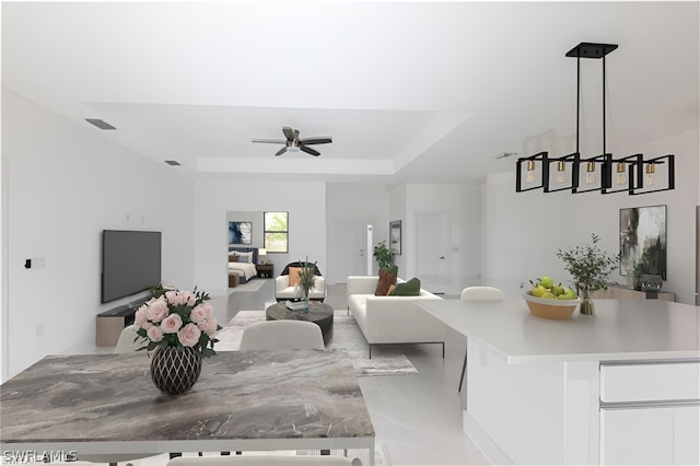 living room with ceiling fan and a raised ceiling