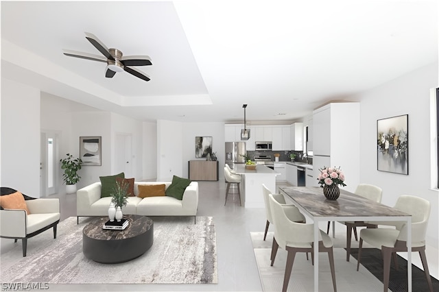 interior space featuring sink, ceiling fan, and a raised ceiling