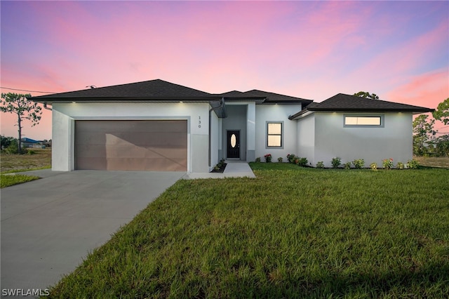 view of front facade with a garage and a yard