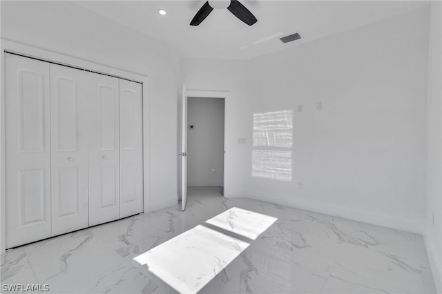 unfurnished bedroom featuring a closet, light tile flooring, and ceiling fan