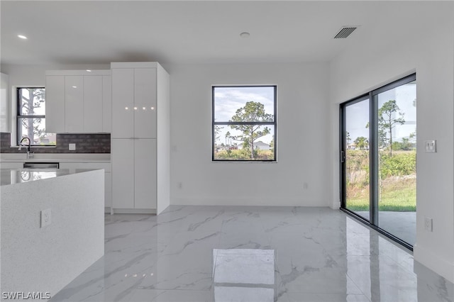 kitchen with plenty of natural light, white cabinetry, and light tile floors