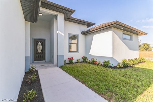 doorway to property featuring a lawn