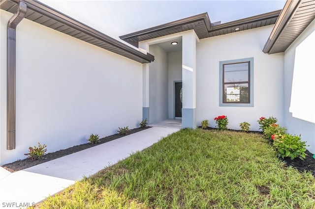 property entrance featuring a lawn