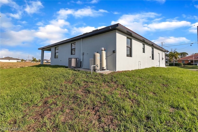 back of property featuring a lawn and central air condition unit