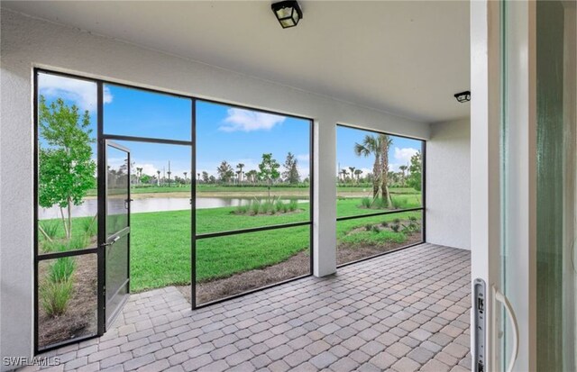 unfurnished sunroom featuring a water view