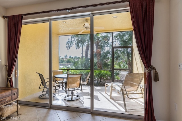 doorway to outside featuring light tile floors and ceiling fan