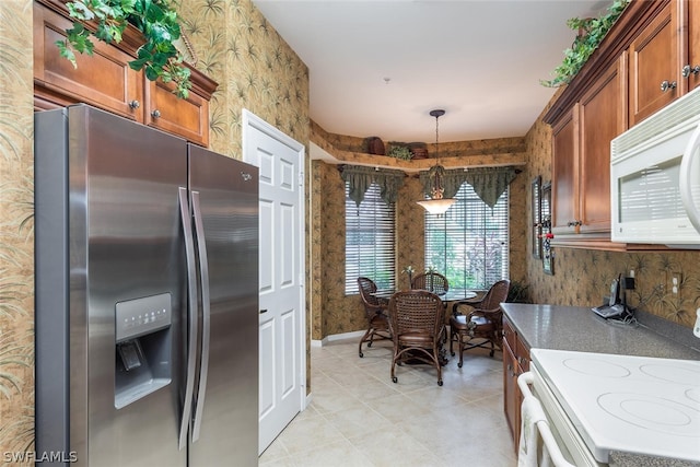 kitchen with hanging light fixtures, white appliances, light tile flooring, and a notable chandelier