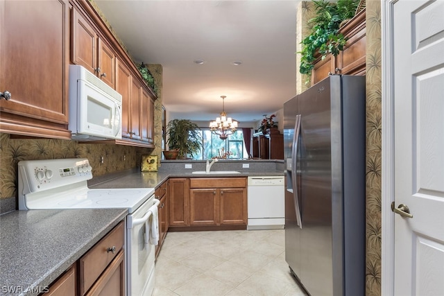 kitchen featuring hanging light fixtures, light tile flooring, white appliances, sink, and a chandelier