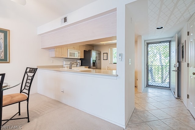 kitchen with sink, light brown cabinets, stainless steel refrigerator with ice dispenser, and light tile flooring