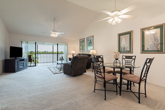 carpeted dining space with high vaulted ceiling and ceiling fan