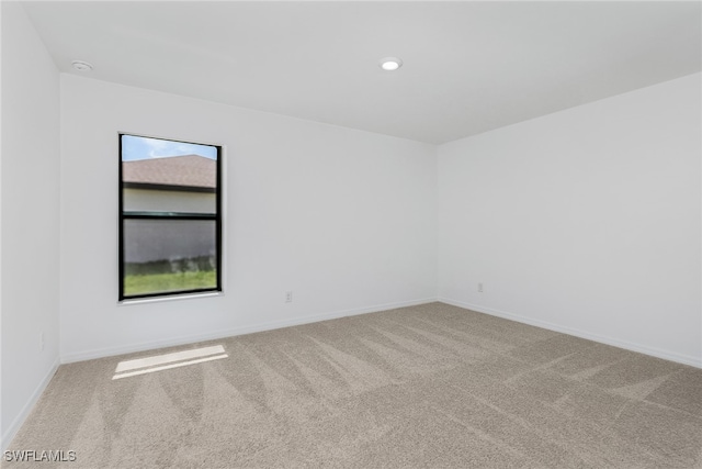 carpeted spare room featuring recessed lighting and baseboards