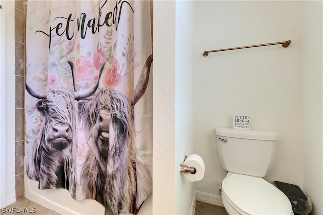 bathroom featuring tile patterned floors, curtained shower, and toilet