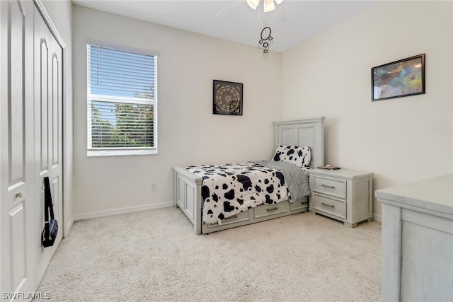 carpeted bedroom featuring ceiling fan and a closet