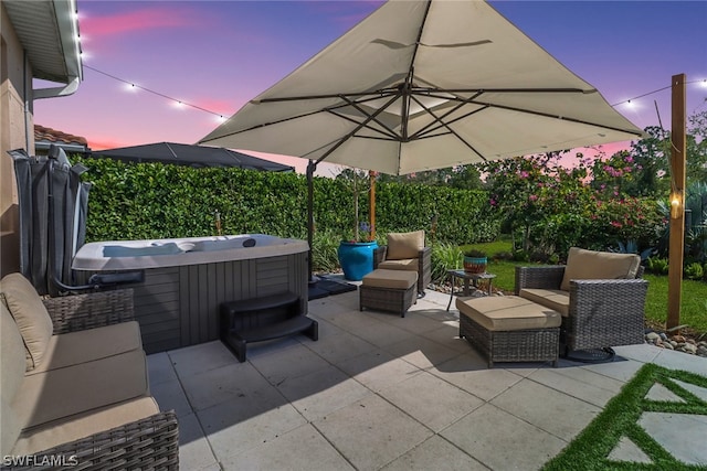 patio terrace at dusk featuring a hot tub