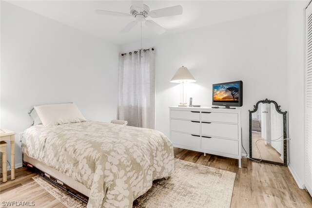 bedroom with wood finished floors, a ceiling fan, and baseboards