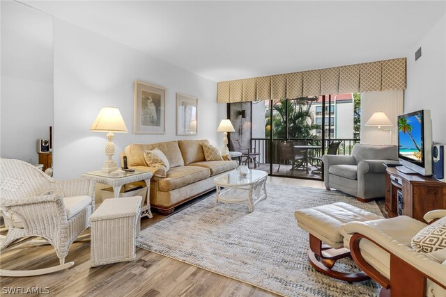 living area with visible vents and wood finished floors